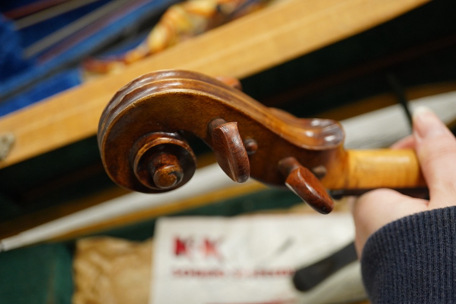 Four cased violins; an early 20th century violin, body 36cm, fitted with a microphone pick up taking a quarter inch jack plug, an early 20th century half size violin, body 32cm, and two student violins. Condition - poor